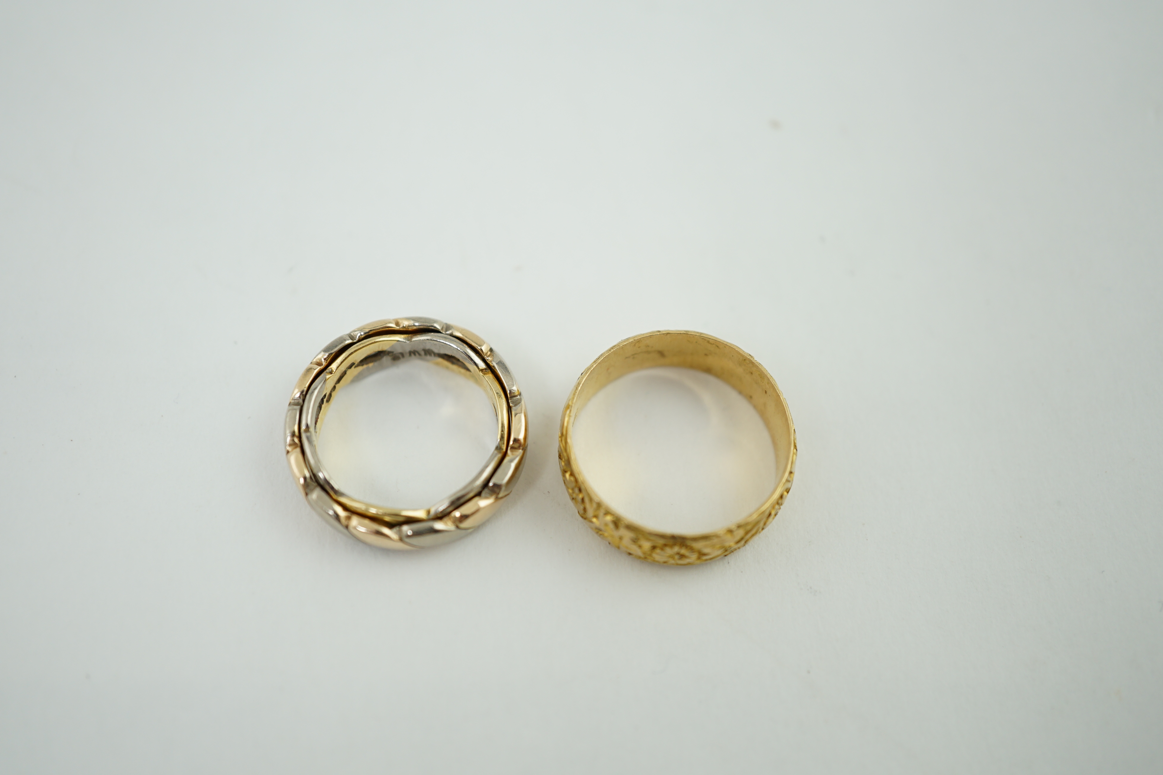 A George V engraved 18ct gold band, size M/N, together with two three or two colour 18ct gold bands